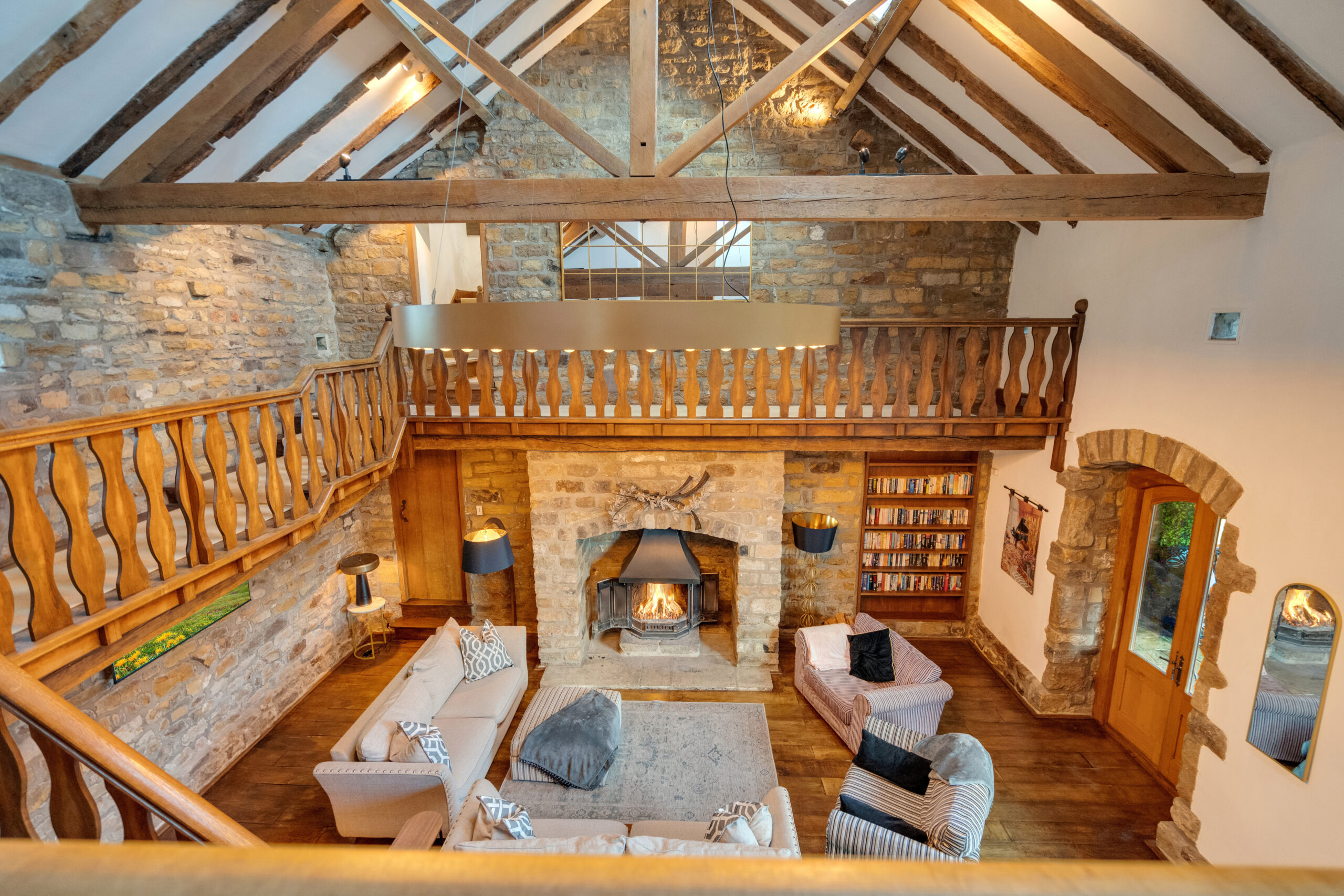open plan mezzanine and sitting area with a roaring log burner